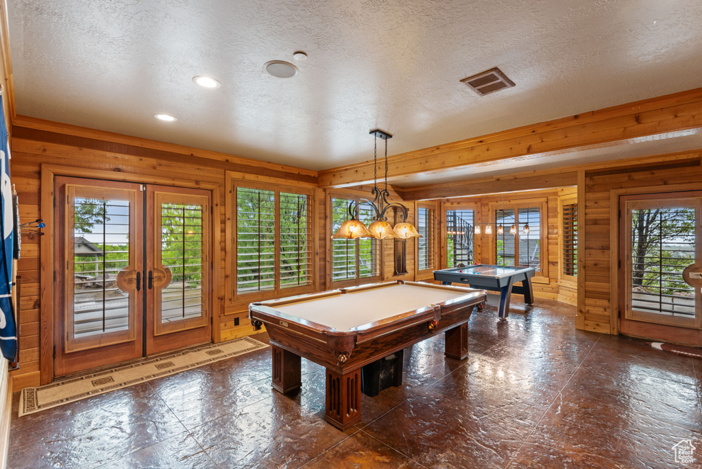 Rec room with french doors, wooden walls, billiards, and a textured ceiling