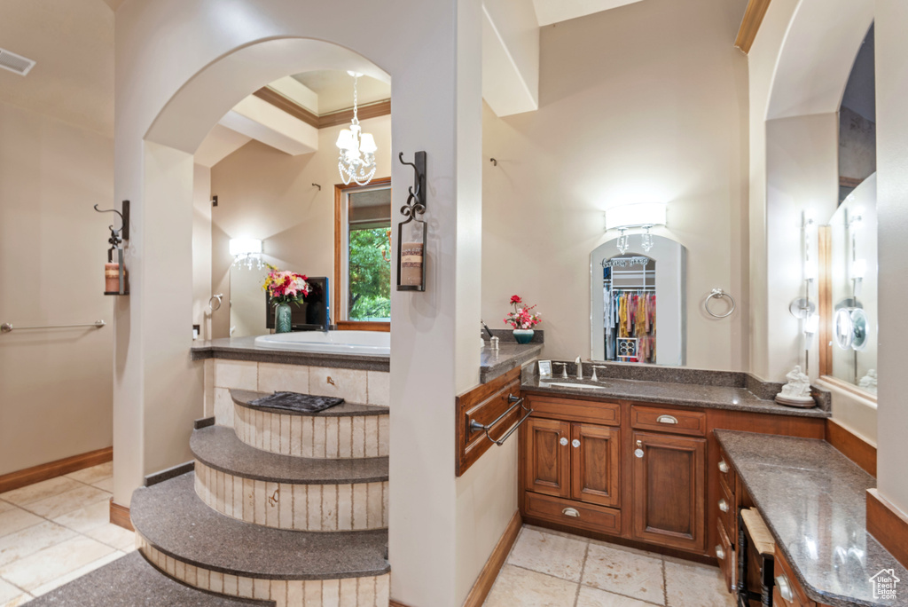 Bathroom with tile floors, ornamental molding, a bathing tub, and vanity