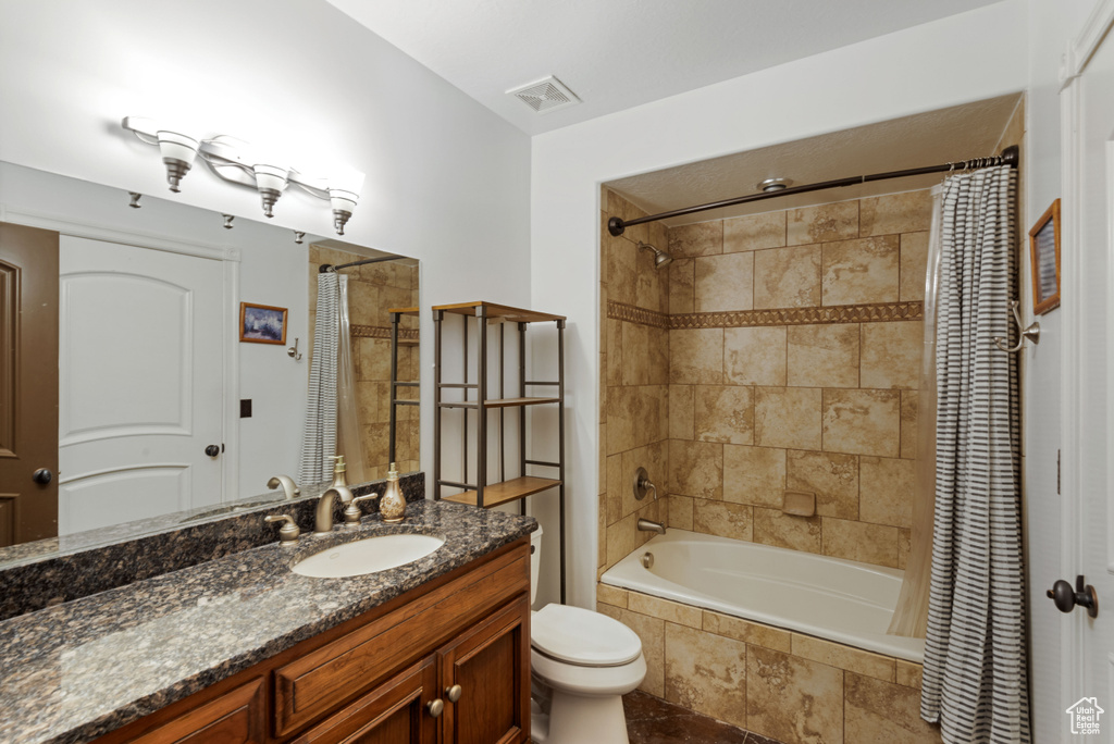 Full bathroom with shower / tub combo, vanity, and toilet