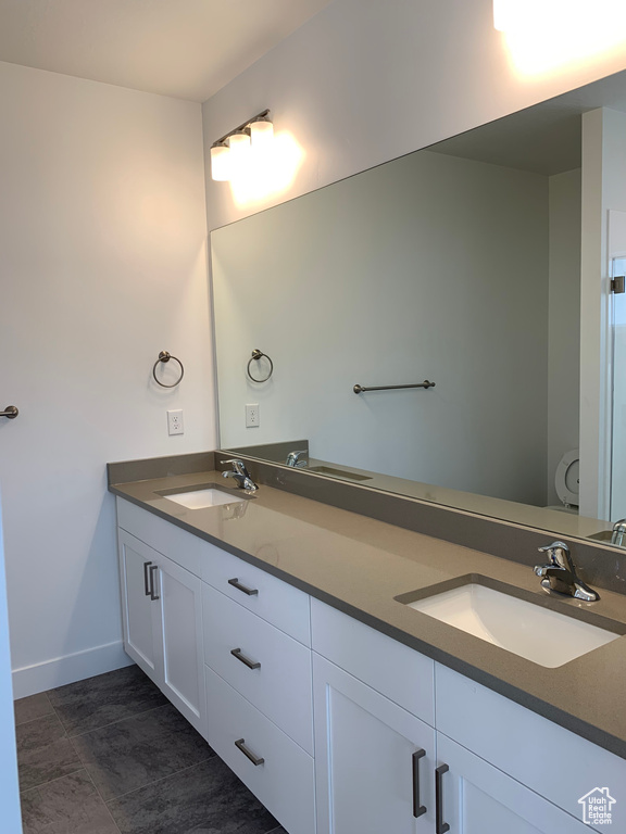 Bathroom with dual vanity and tile flooring