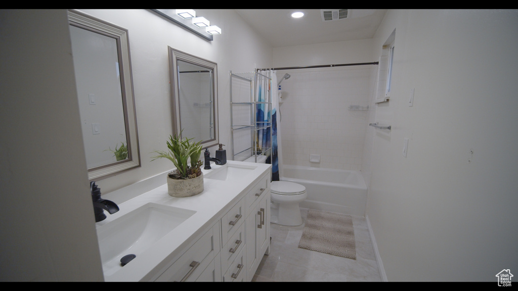 Full bathroom featuring shower / bathtub combination with curtain, tile flooring, double vanity, and toilet