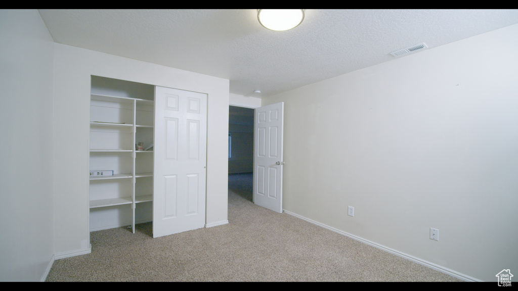 Unfurnished bedroom featuring carpet and a closet