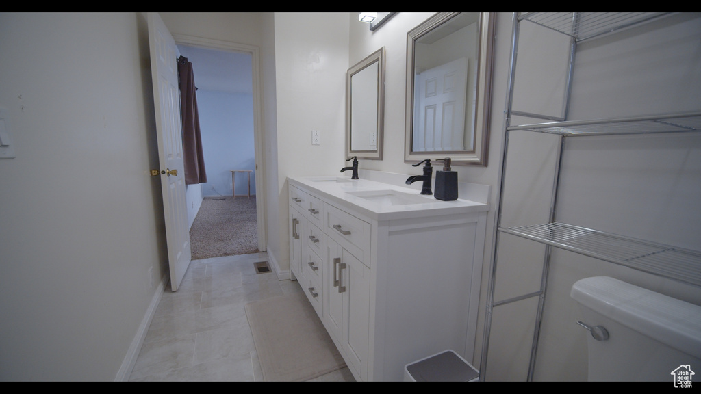 Bathroom featuring oversized vanity, toilet, and tile floors