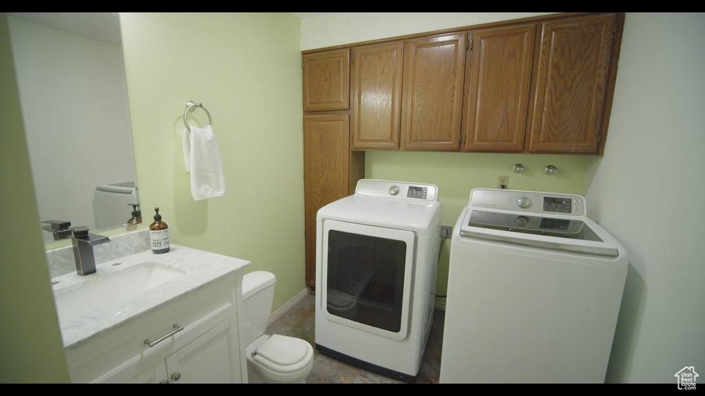 Washroom with sink, tile floors, and washing machine and dryer