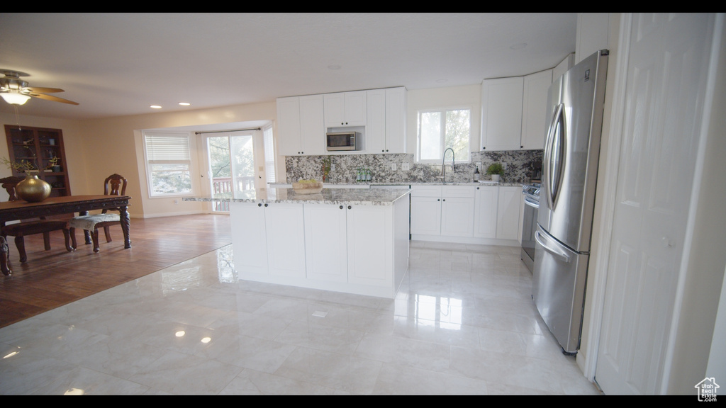 Kitchen featuring a kitchen island, plenty of natural light, and light tile flooring