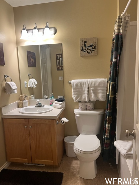 Bathroom featuring tile flooring, vanity, and toilet