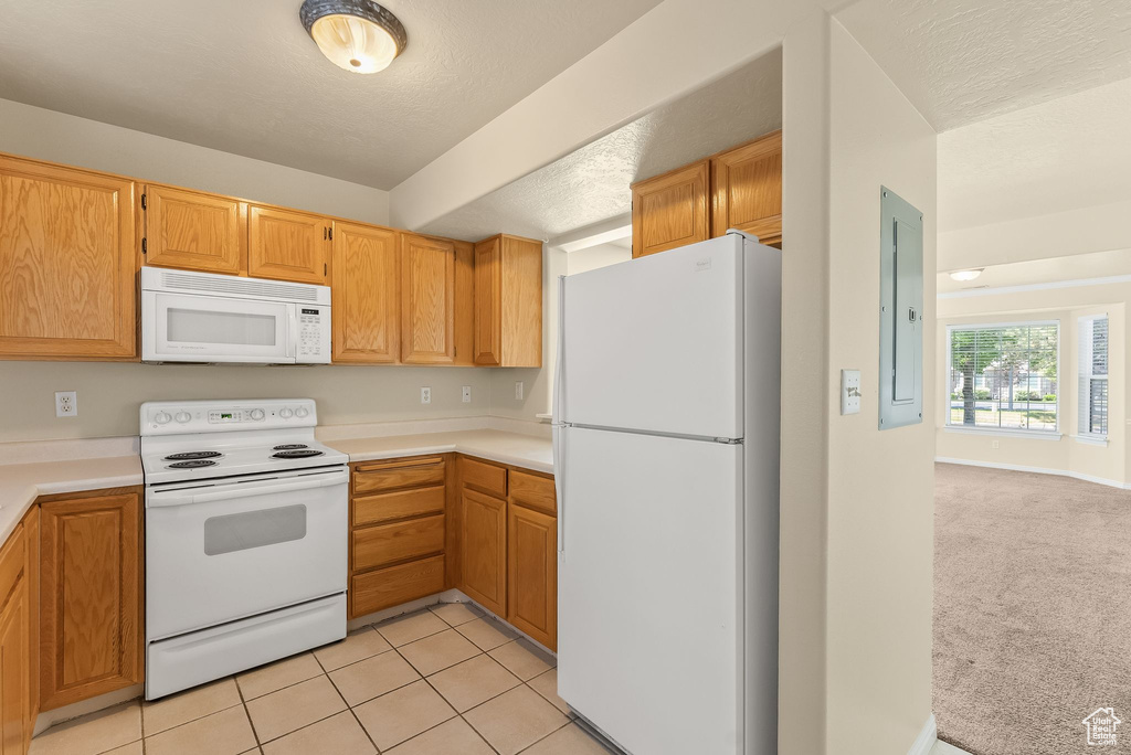 Kitchen with light carpet and white appliances