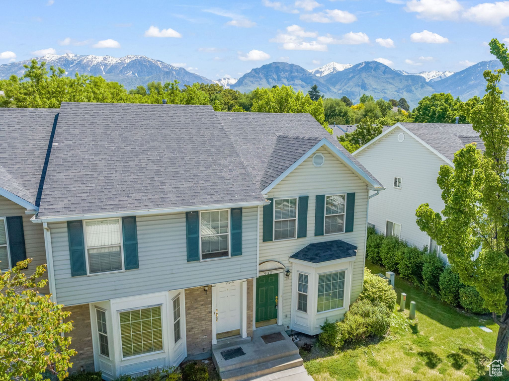 View of front of home with a front yard and a mountain view