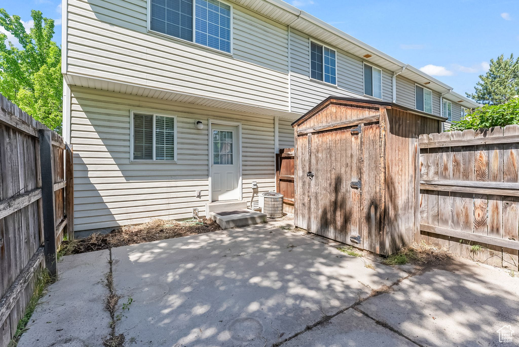 Rear view of house with a patio area, a shed, and central air condition unit