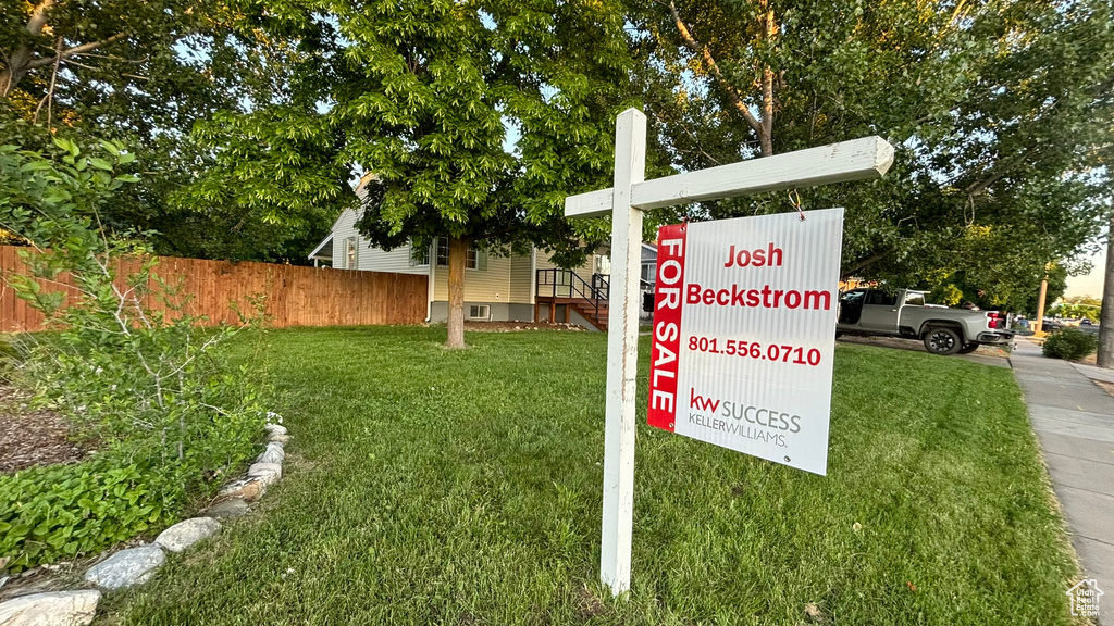 Community / neighborhood sign featuring a yard