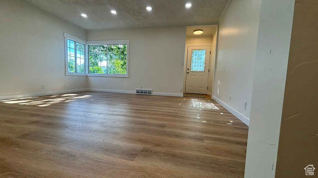 Empty room featuring hardwood / wood-style flooring and a textured ceiling