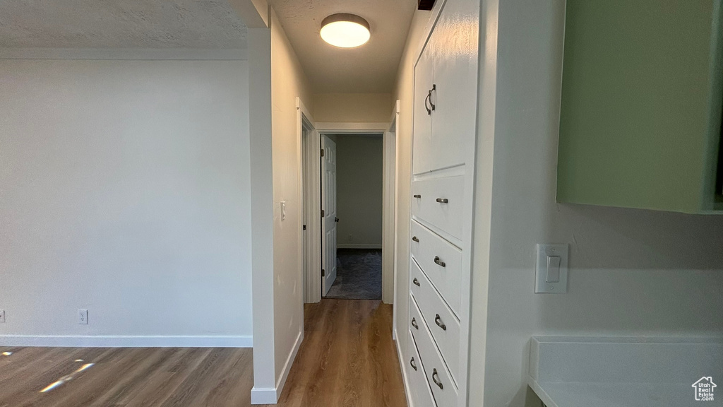 Corridor with hardwood / wood-style flooring