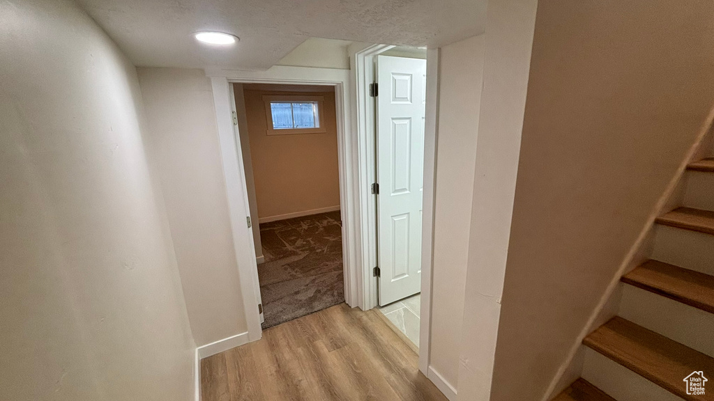 Hallway featuring light hardwood / wood-style floors and a textured ceiling