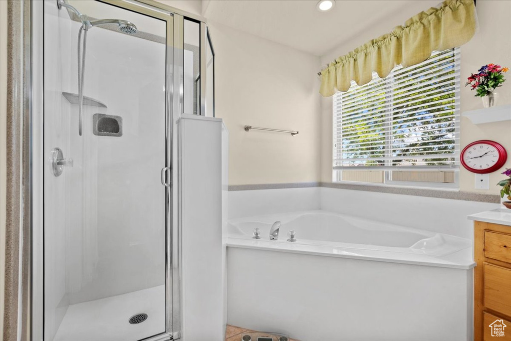 Bathroom featuring vanity and independent shower and bath