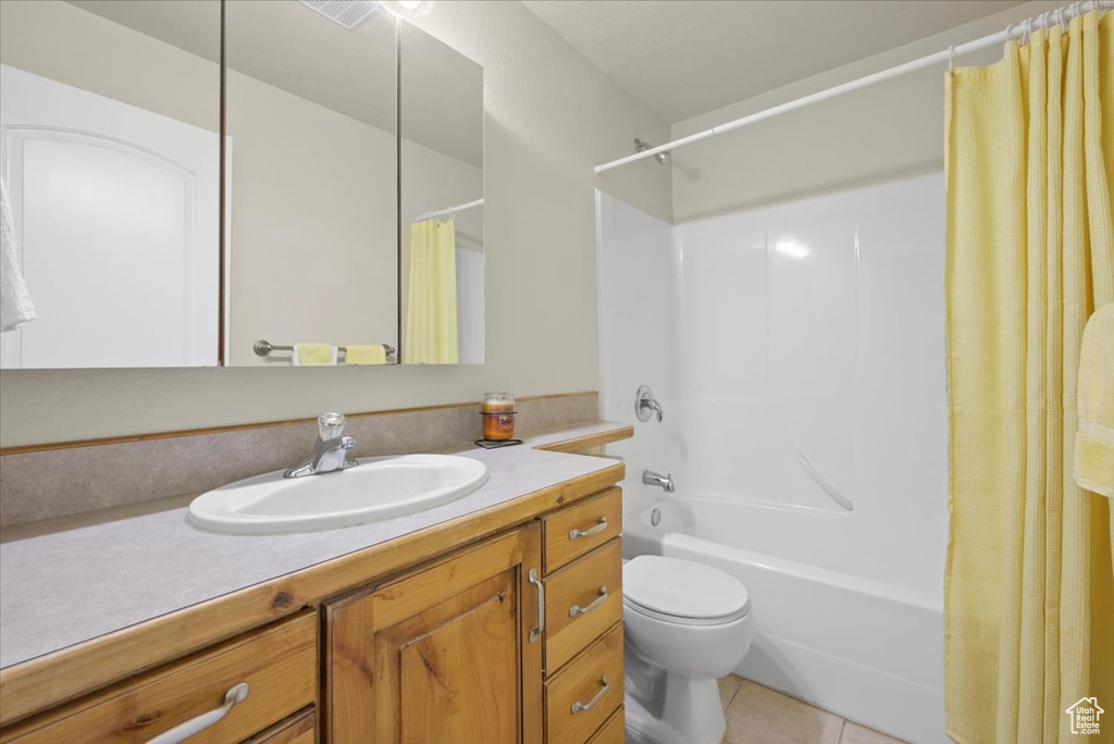 Full bathroom with tile flooring, shower / tub combo with curtain, vanity, and toilet