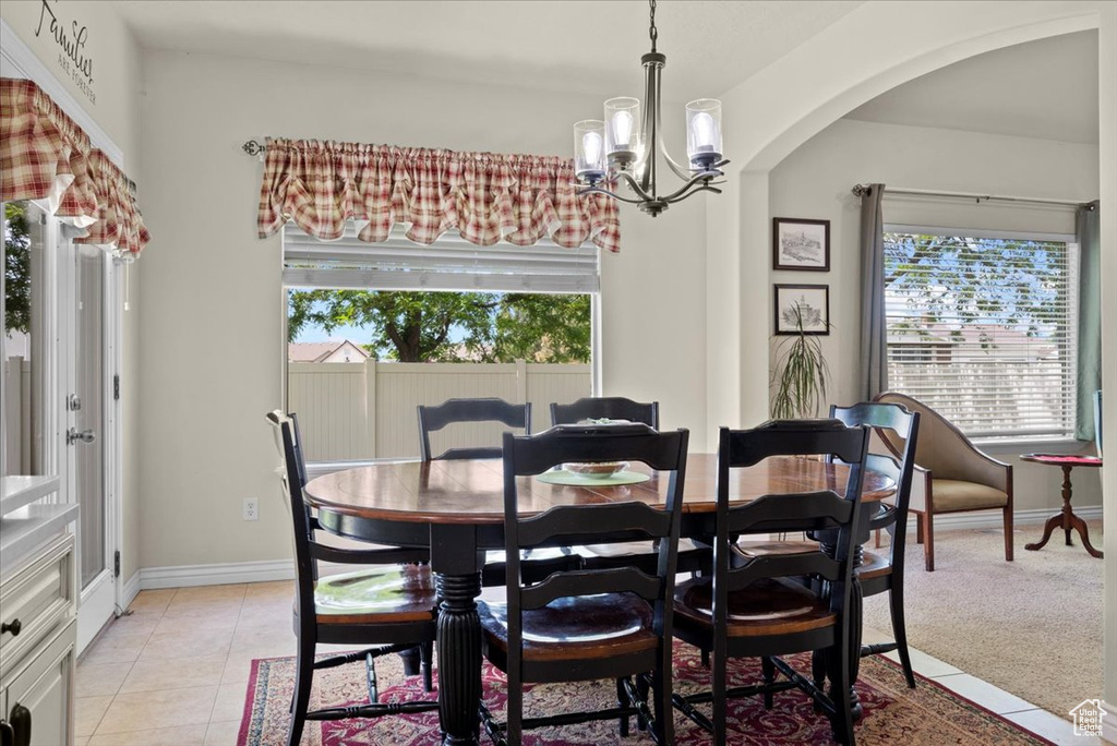 Tiled dining room with a notable chandelier and plenty of natural light