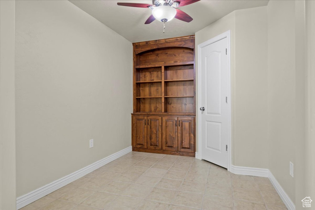 Tiled empty room featuring ceiling fan