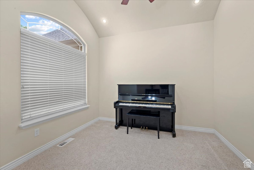 Misc room with ceiling fan, carpet floors, and lofted ceiling