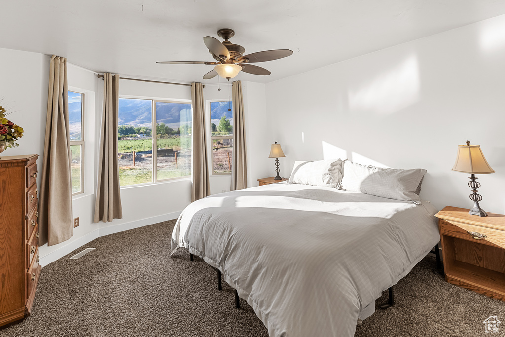 Bedroom featuring dark carpet and ceiling fan