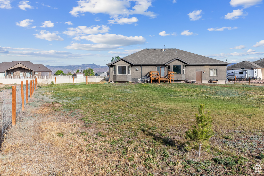 Exterior space with a deck with mountain view and a yard