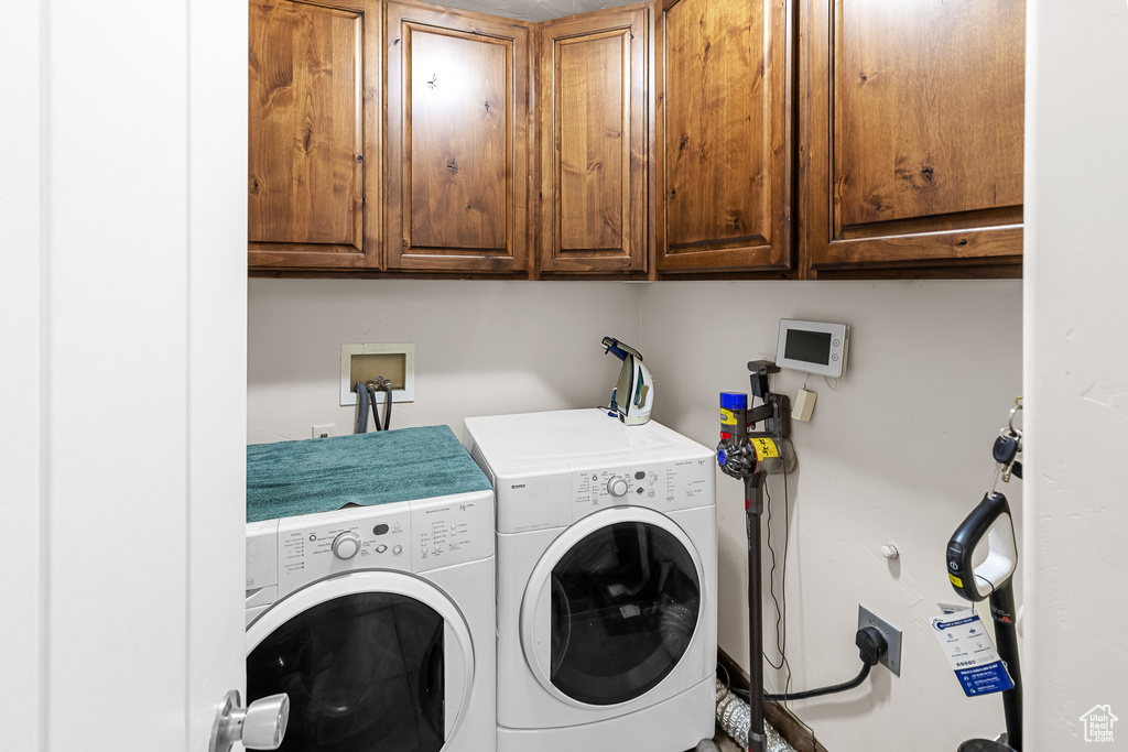 Washroom featuring cabinets, washer hookup, and washing machine and clothes dryer