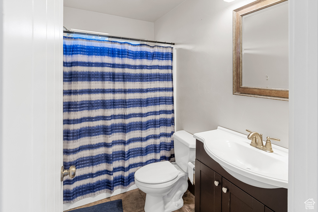 Bathroom with tile flooring, large vanity, and toilet