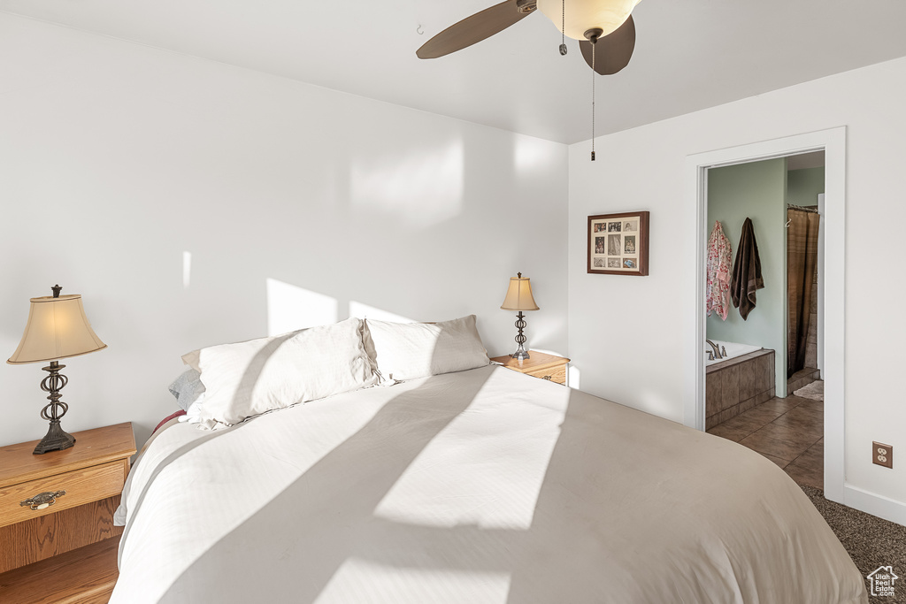 Tiled bedroom featuring ceiling fan and ensuite bathroom