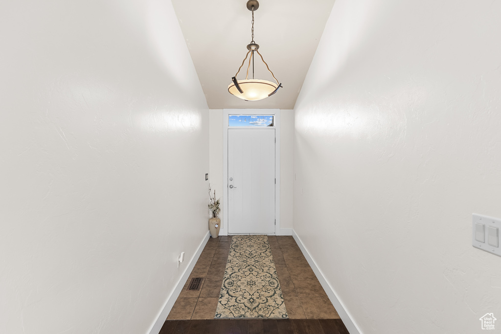 Entryway with lofted ceiling and dark tile floors