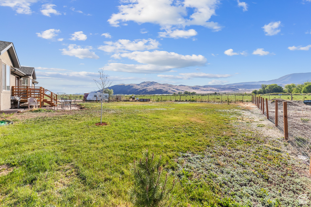 View of yard featuring a deck with mountain view and a rural view