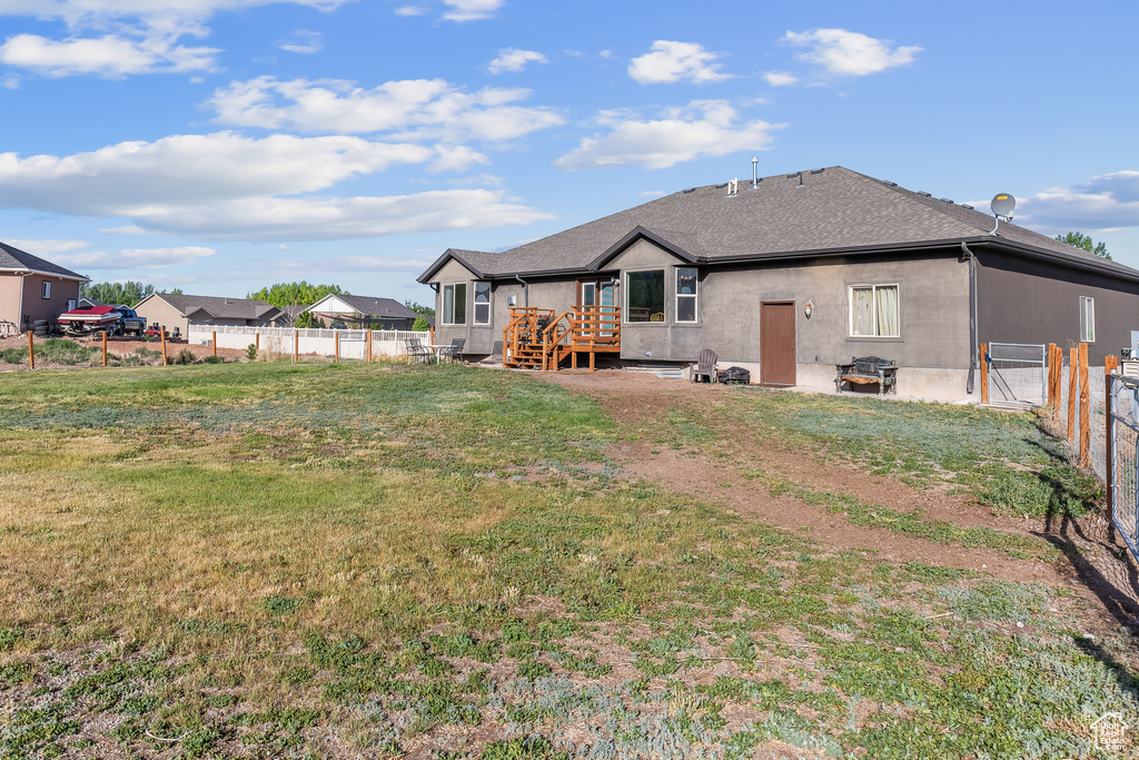 Back of property with a deck and a lawn