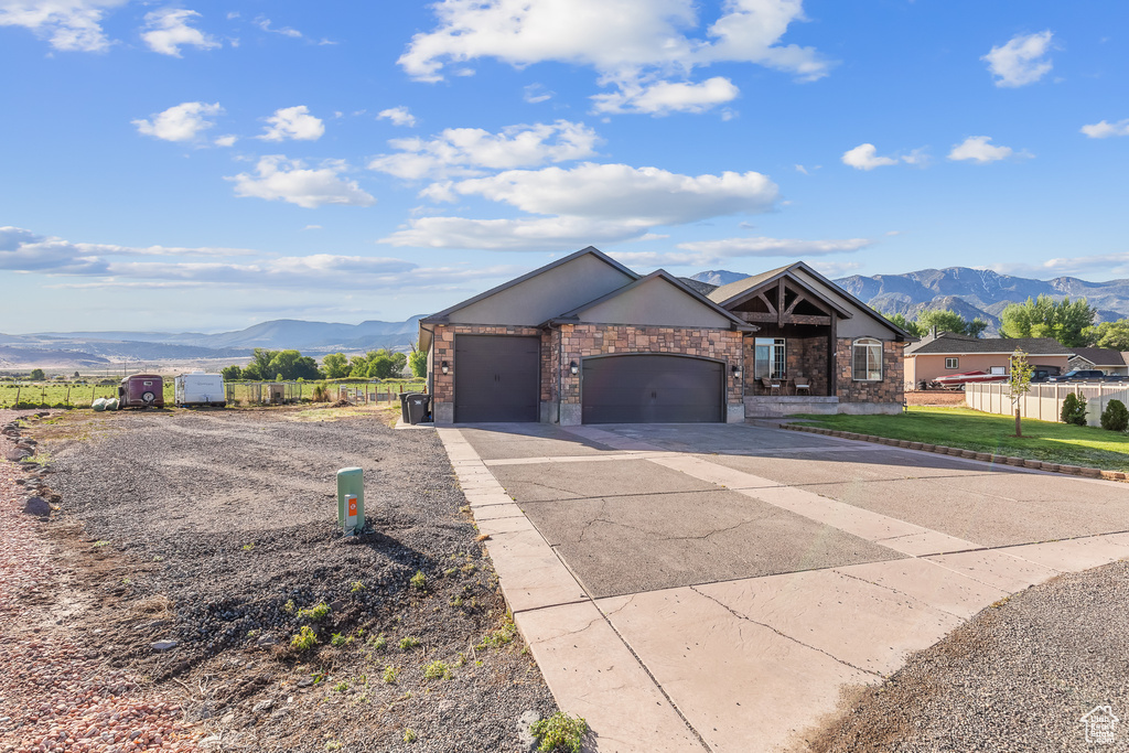 View of front facade with a garage and a mountain view