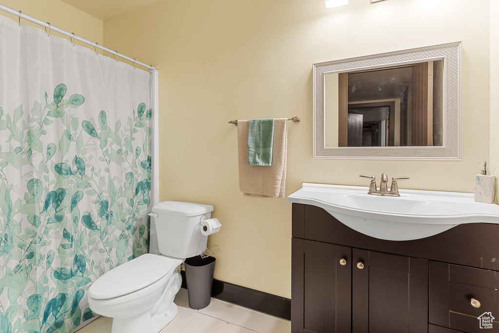 Bathroom with tile floors, oversized vanity, and toilet