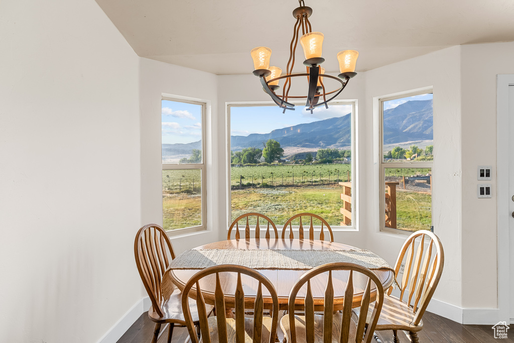 Dining area featuring a mountain view, dark hardwood / wood-style flooring, a wealth of natural light, and an inviting chandelier