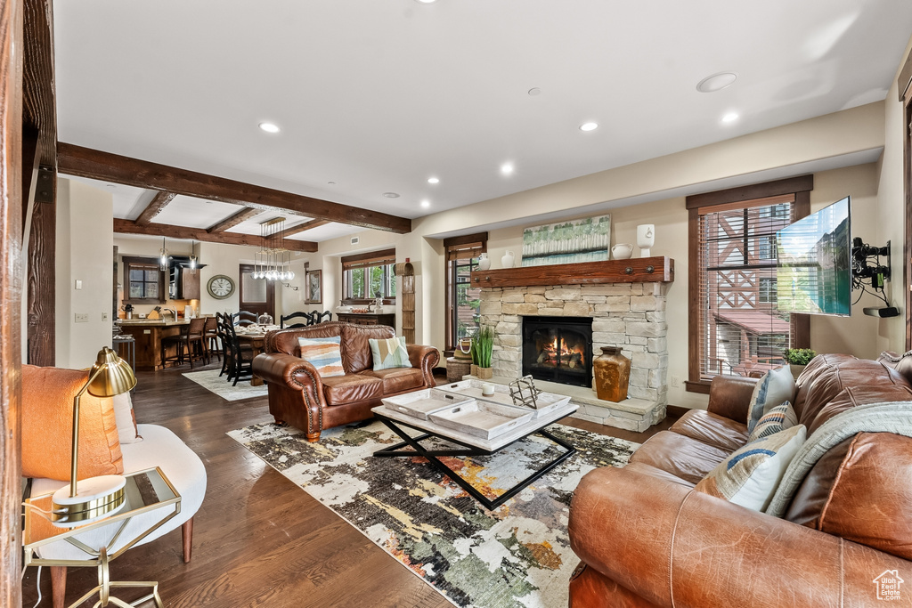 Living room featuring beamed ceiling, dark hardwood / wood-style flooring, and a fireplace