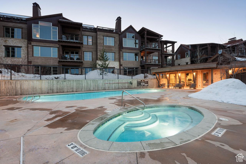 View of pool with a patio area and a hot tub