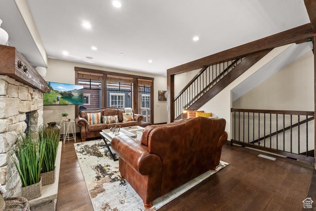 Living room with dark hardwood / wood-style flooring and a fireplace