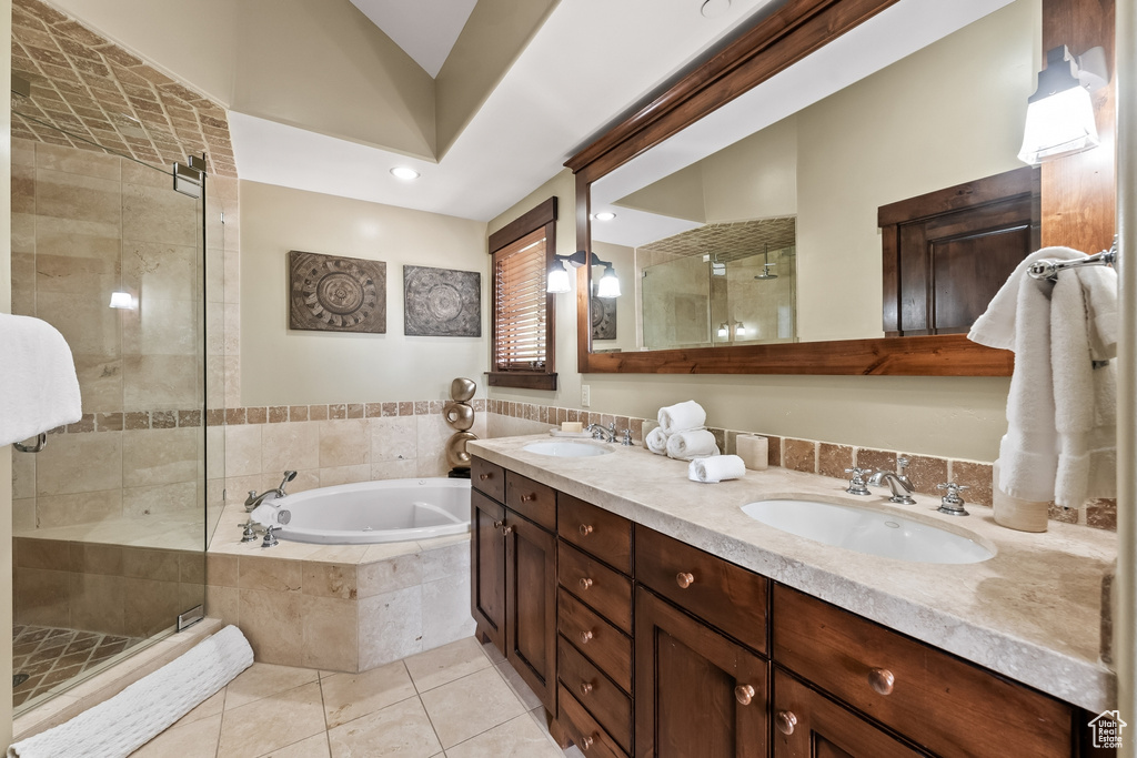 Bathroom with tile floors, dual bowl vanity, and plus walk in shower