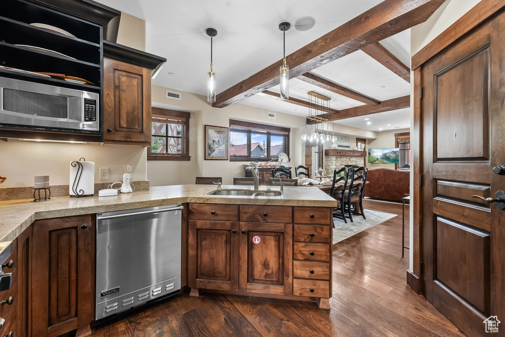 Kitchen with appliances with stainless steel finishes, sink, dark wood-type flooring, and pendant lighting