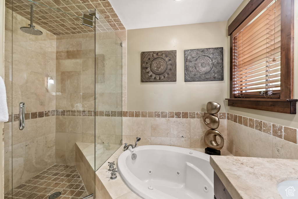 Bathroom featuring tile walls and independent shower and bath