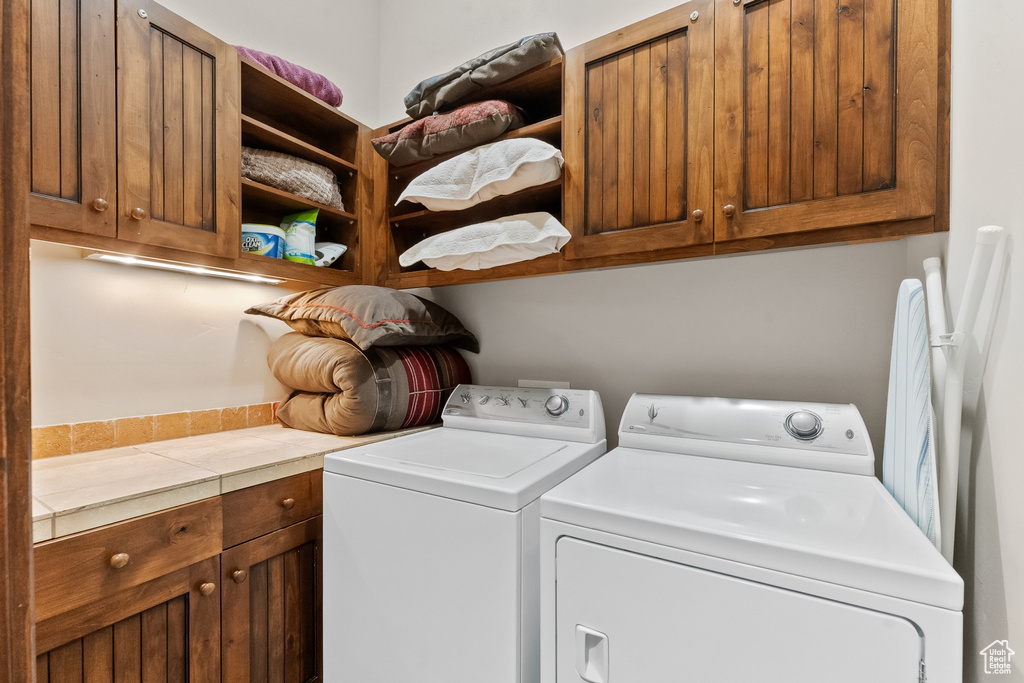 Laundry room with separate washer and dryer and cabinets