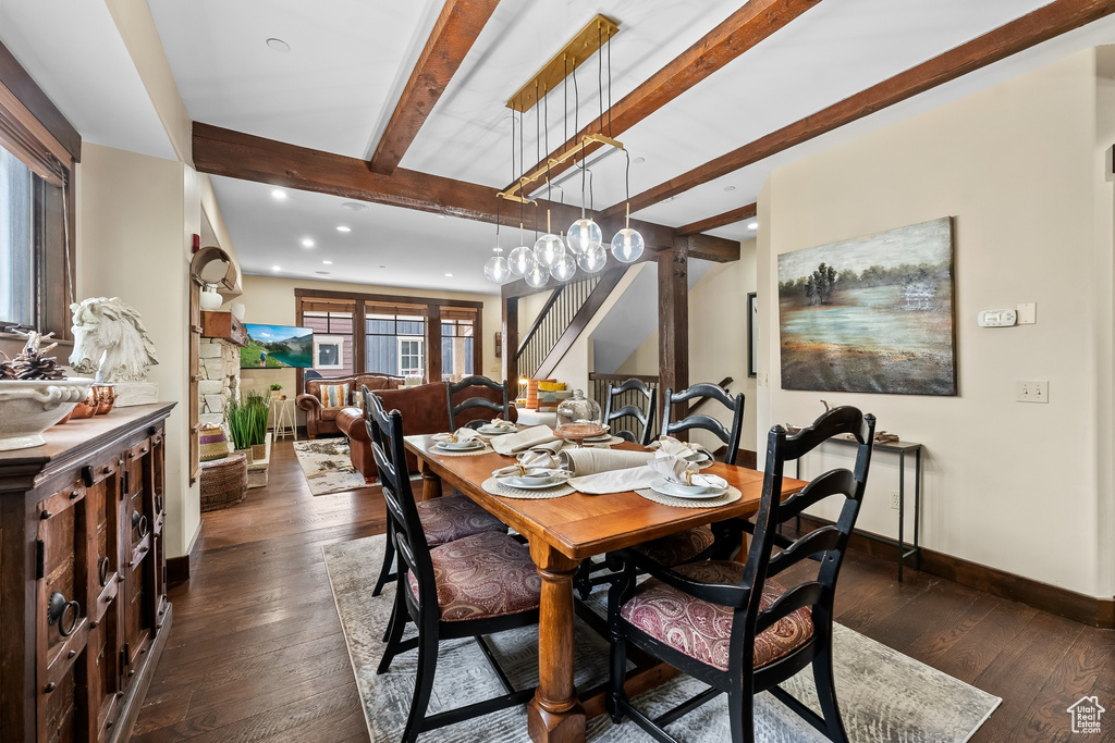 Dining room featuring dark wood-type flooring and beamed ceiling