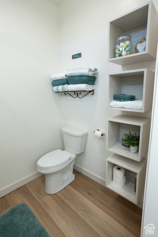 Bathroom with toilet and hardwood / wood-style flooring