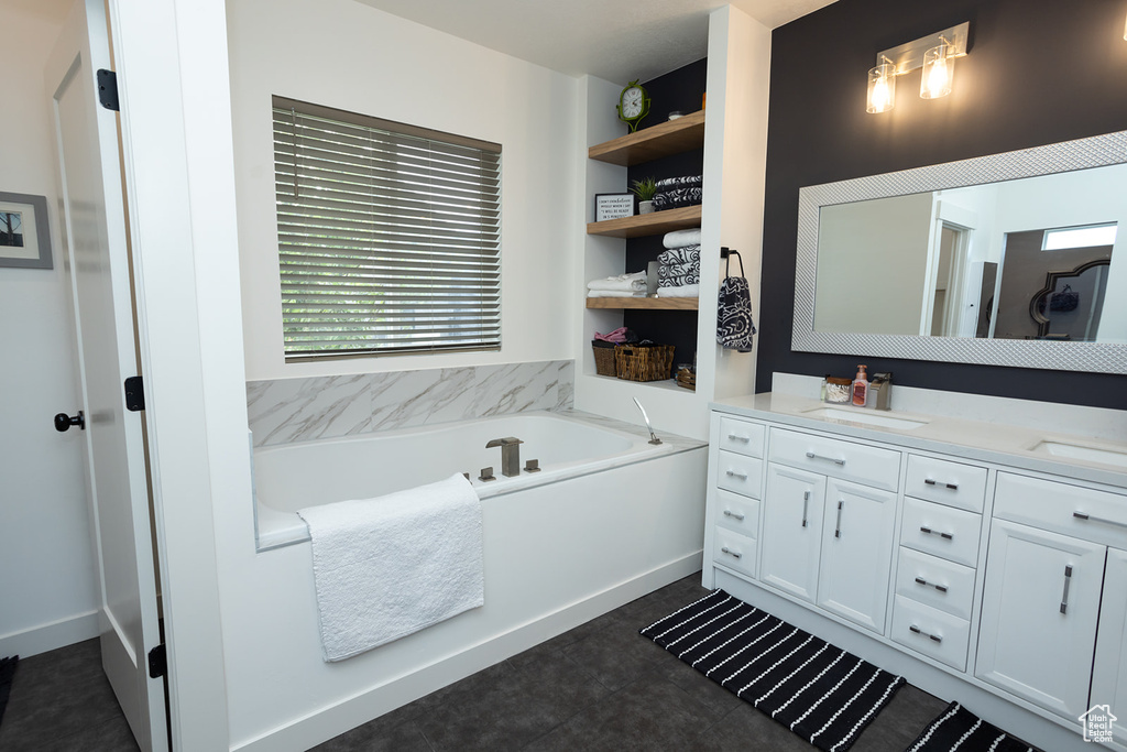 Bathroom with a tub, vanity, tile floors, and a healthy amount of sunlight