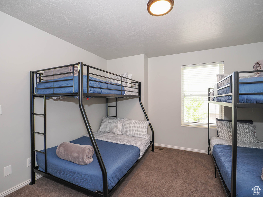 Carpeted bedroom featuring a textured ceiling