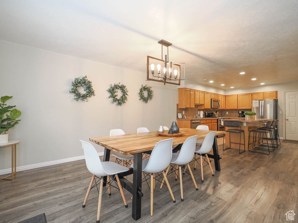 Dining space featuring a notable chandelier and hardwood / wood-style flooring