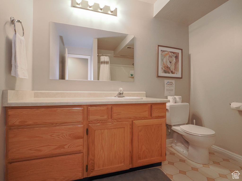 Bathroom with vanity, toilet, and tile floors