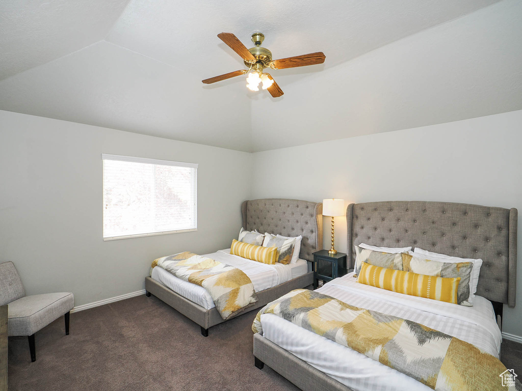 Carpeted bedroom with ceiling fan and vaulted ceiling