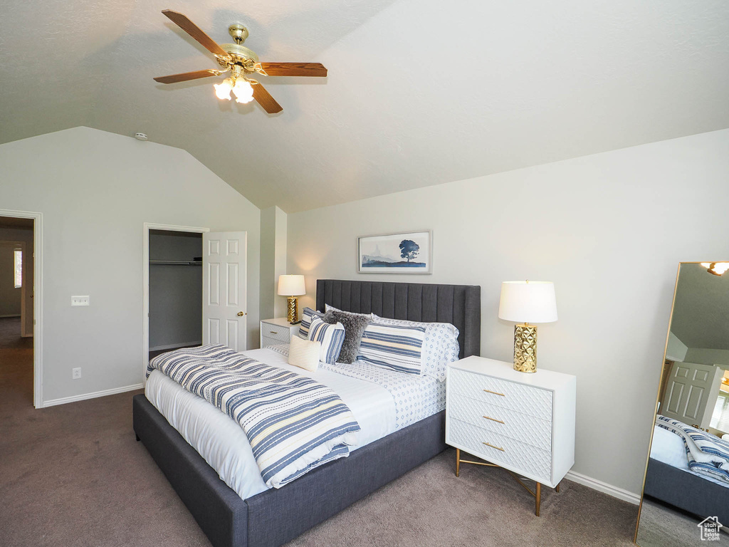 Bedroom featuring a closet, ceiling fan, vaulted ceiling, and dark carpet