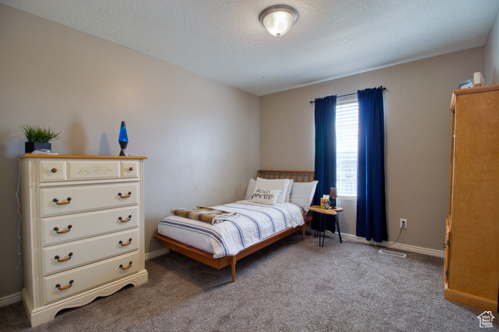 Bedroom featuring a textured ceiling and carpet flooring