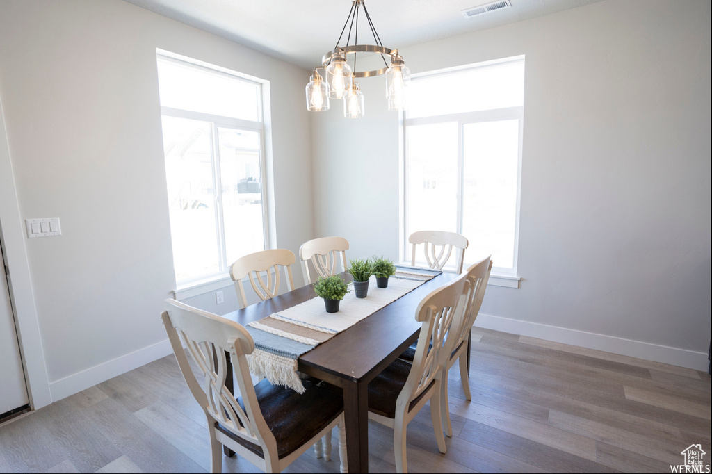 Dining area featuring a notable chandelier and hardwood / wood-style flooring